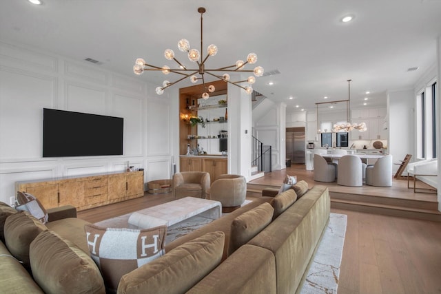 3502 Dorset Cliff Ln, Houston, TX 77055 - living room with a chandelier, a decorative wall, light wood finished floors, recessed lighting, and stairway