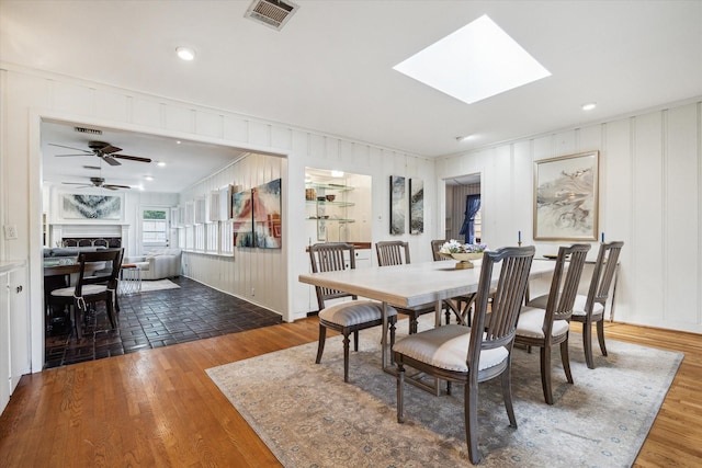 6249 Piping Rock Ln, Houston, TX 77057 - dining room with a fireplace, crown molding, wood finished floors, a ceiling fan, and a skylight