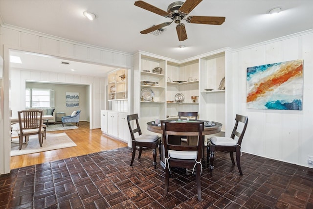 6249 Piping Rock Ln, Houston, TX 77057 - dining area featuring a ceiling fan, crown molding, and wood walls