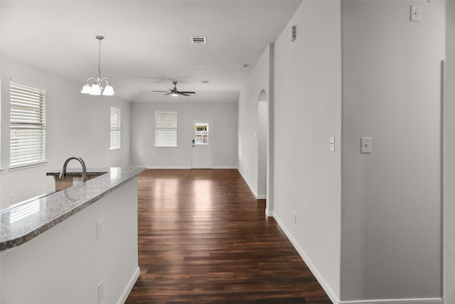 23753 Briar Tree Dr, Porter, TX 77365 - kitchen with dark wood finished floors, light stone countertops, ceiling fan, hanging light fixtures, and arched walkways