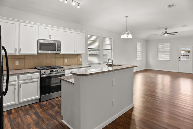 23753 Briar Tree Dr, Porter, TX 77365 - kitchen with appliances with stainless steel finishes, open floor plan, dark wood finished floors, tasteful backsplash, and a ceiling fan