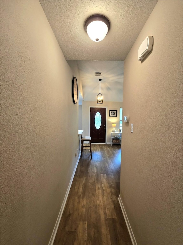 110 Red Bud St, Shepherd, TX 77371 - hallway with dark wood-style flooring, a textured ceiling, and a textured wall