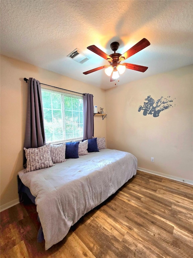 110 Red Bud St, Shepherd, TX 77371 - bedroom with a textured ceiling, wood finished floors, and a ceiling fan