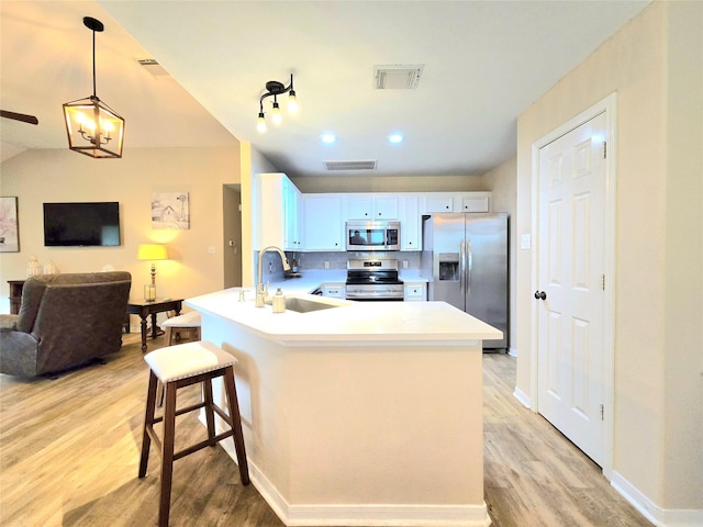 110 Red Bud St, Shepherd, TX 77371 - kitchen featuring stainless steel appliances, a peninsula, light wood finished floors, open floor plan, and a kitchen bar
