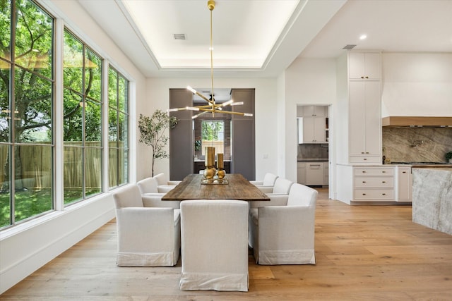 3755 Rice Blvd, Houston, TX 77005 - dining space featuring a chandelier, a tray ceiling, light wood-style flooring, and recessed lighting