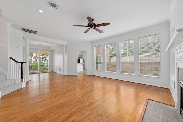4444 Victory Dr Unit 26, Houston, TX 77088 - unfurnished living room with crown molding, stairway, light wood finished floors, ceiling fan, and a fireplace with flush hearth