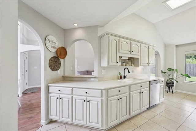 505 Shannons Way, Bridge City, TX 77611 - kitchen featuring arched walkways, dishwasher, light countertops, light tile patterned floors, and vaulted ceiling