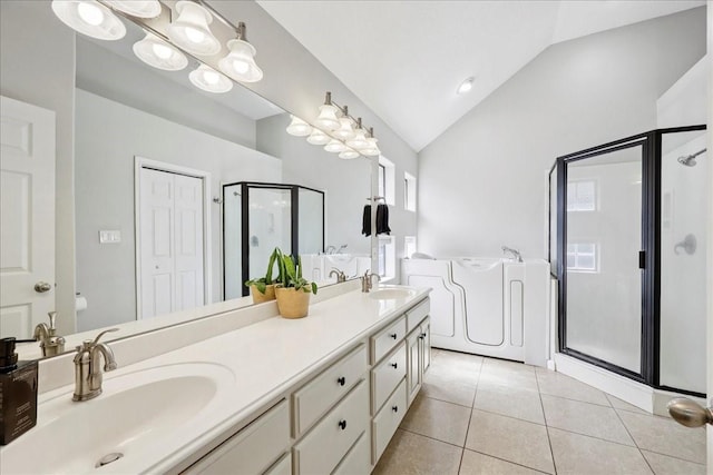 505 Shannons Way, Bridge City, TX 77611 - bathroom with a shower stall, vaulted ceiling, a garden tub, double vanity, and tile patterned floors