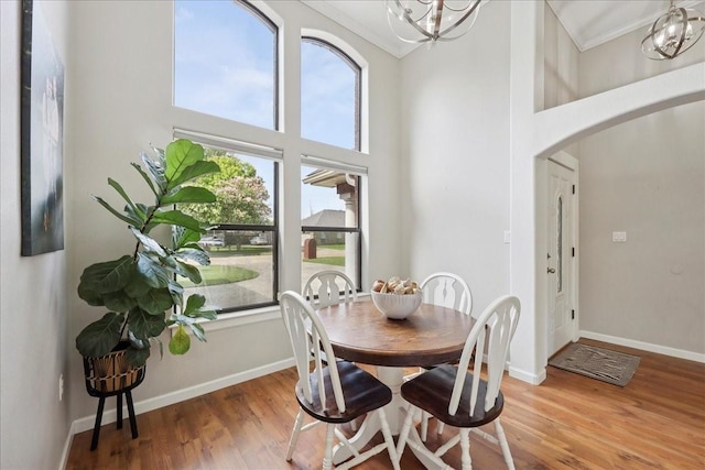 505 Shannons Way, Bridge City, TX 77611 - dining space featuring arched walkways, a high ceiling, wood finished floors, a chandelier, and ornamental molding