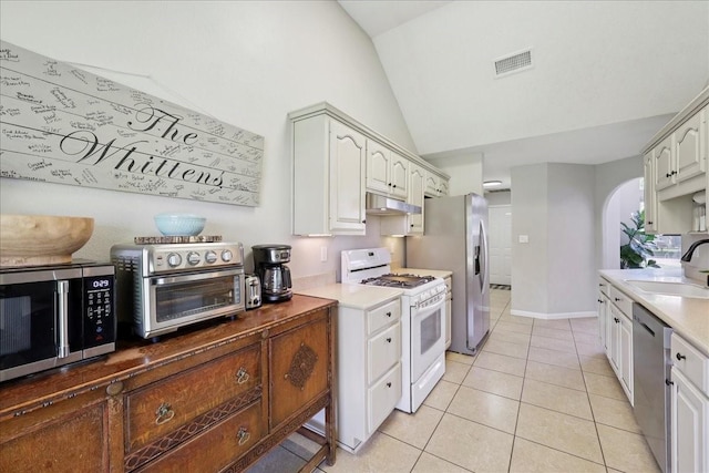 505 Shannons Way, Bridge City, TX 77611 - kitchen with appliances with stainless steel finishes, under cabinet range hood, lofted ceiling, light tile patterned flooring, and light countertops