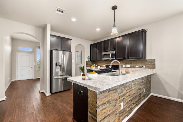 9422 Cimarroncito Ln, Humble, TX 77396 - kitchen featuring stainless steel appliances, arched walkways, dark wood finished floors, light countertops, and recessed lighting