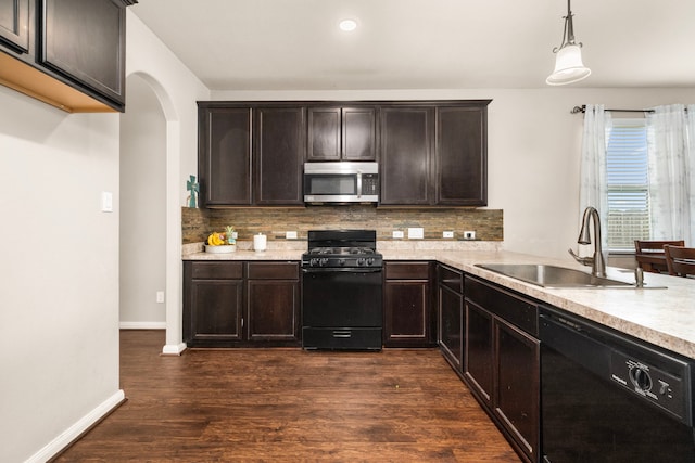 9422 Cimarroncito Ln, Humble, TX 77396 - kitchen with black appliances, light countertops, arched walkways, dark brown cabinets, and recessed lighting