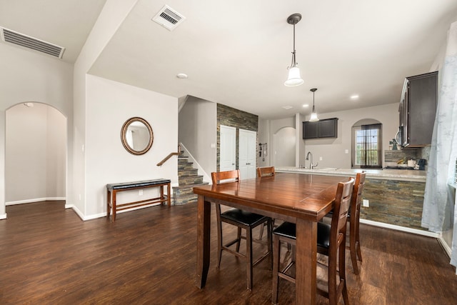 9422 Cimarroncito Ln, Humble, TX 77396 - dining space with arched walkways, dark wood finished floors, stairs, and recessed lighting