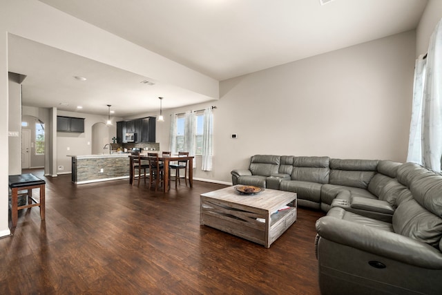 9422 Cimarroncito Ln, Humble, TX 77396 - living room with arched walkways and dark wood-type flooring