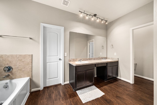 9422 Cimarroncito Ln, Humble, TX 77396 - bathroom with double vanity, a bath, and wood finished floors