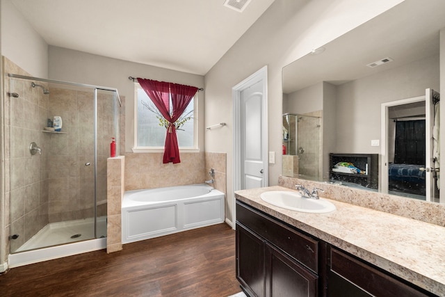 9422 Cimarroncito Ln, Humble, TX 77396 - bathroom with a bath, a stall shower, wood finished floors, vanity, and ensuite bath