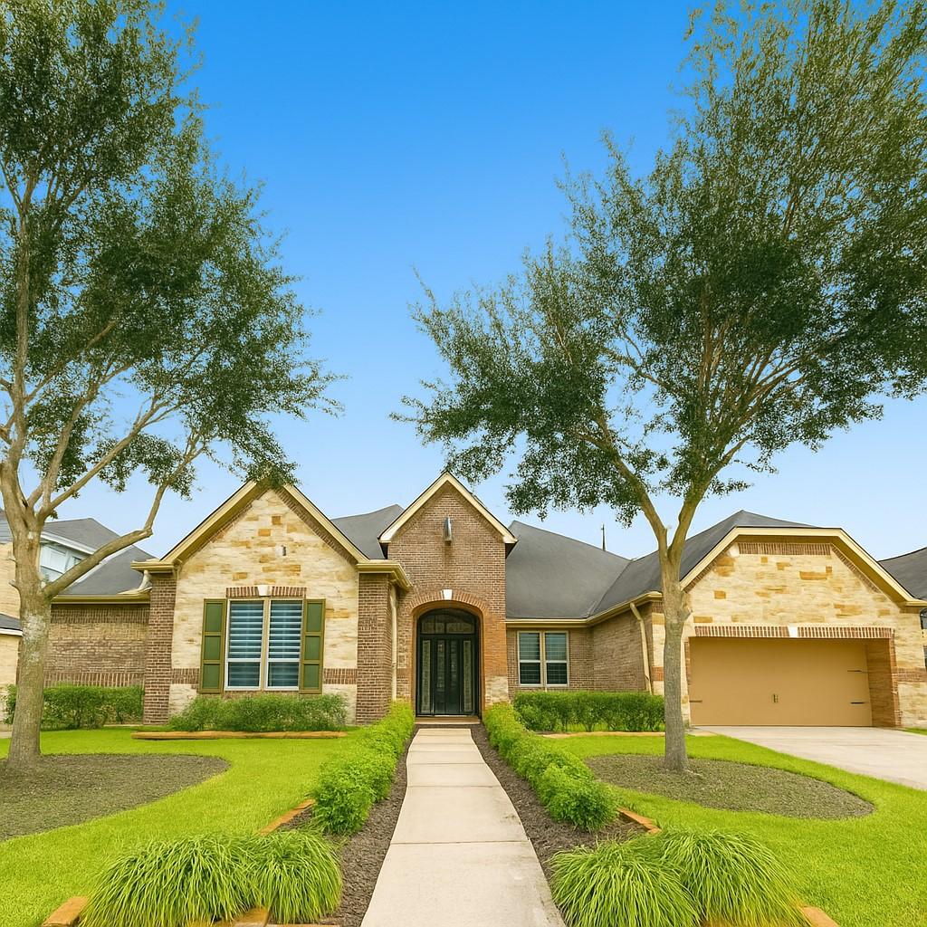 47 Trento Turn Dr, Missouri City, TX 77459 - view of front facade featuring an attached garage, brick siding, concrete driveway, and stone siding