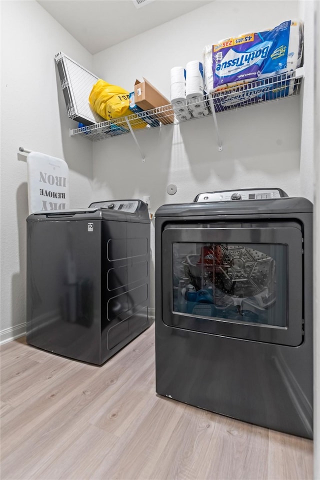 10731 Spring Brook Pass Dr, Humble, TX 77396 - washroom with washing machine and dryer and wood finished floors