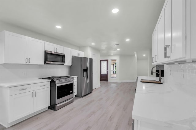 1602 Pine Oak Dr, Conroe, TX 77304 - kitchen with appliances with stainless steel finishes, decorative backsplash, white cabinetry, and recessed lighting