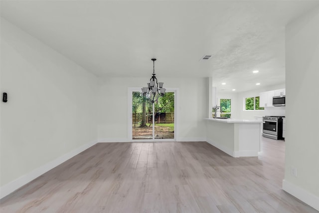 1602 Pine Oak Dr, Conroe, TX 77304 - unfurnished dining area with a chandelier, recessed lighting, and light wood-style flooring
