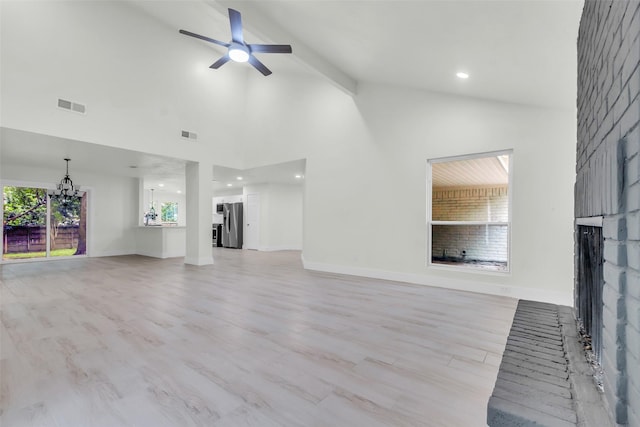 1602 Pine Oak Dr, Conroe, TX 77304 - unfurnished living room with a brick fireplace, a chandelier, a ceiling fan, light wood finished floors, and high vaulted ceiling