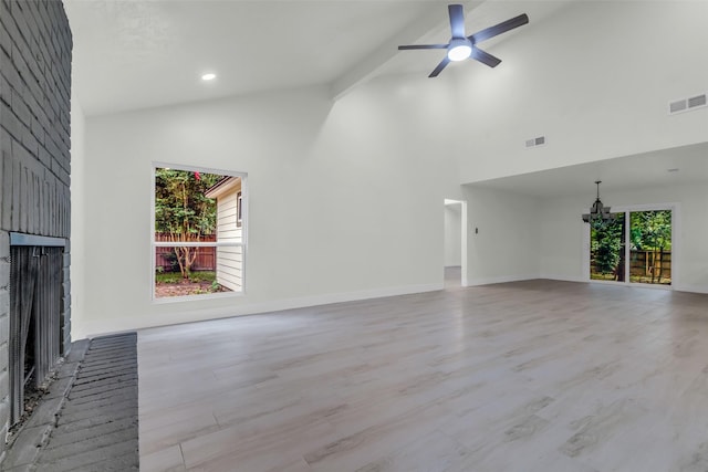 1602 Pine Oak Dr, Conroe, TX 77304 - unfurnished living room with a brick fireplace, high vaulted ceiling, a ceiling fan, light wood-style flooring, and a chandelier