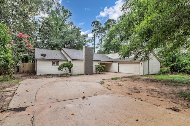 1602 Pine Oak Dr, Conroe, TX 77304 - view of front facade with driveway, a garage, and a chimney