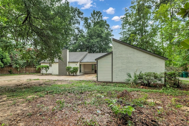 1602 Pine Oak Dr, Conroe, TX 77304 - back of property with a chimney, a patio, and brick siding