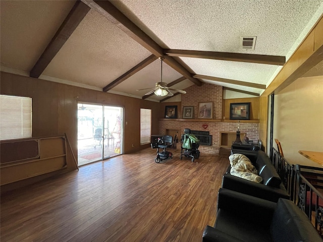 1901 Greenbrook Pkwy, Austin, TX 78723 - living area with wood finished floors, a ceiling fan, a textured ceiling, and a brick fireplace