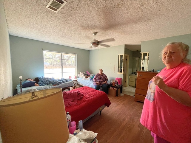 1901 Greenbrook Pkwy, Austin, TX 78723 - bedroom with wood finished floors, a textured ceiling, and ceiling fan