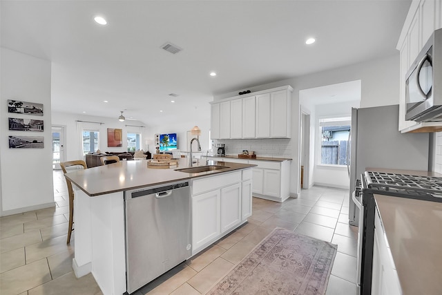 3330 Dagostino Creek Dr, Katy, TX 77494 - kitchen with appliances with stainless steel finishes, tasteful backsplash, healthy amount of natural light, recessed lighting, and white cabinets