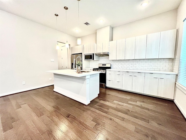 613 Thornton Oaks Ln, Houston, TX 77018 - kitchen featuring stainless steel appliances, dark wood-style flooring, backsplash, light countertops, and an island with sink