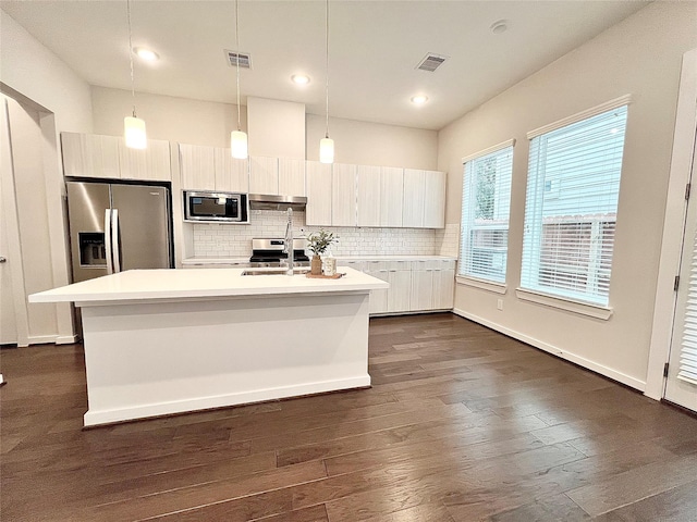 613 Thornton Oaks Ln, Houston, TX 77018 - kitchen with stainless steel appliances, light countertops, dark wood-style floors, an island with sink, and under cabinet range hood