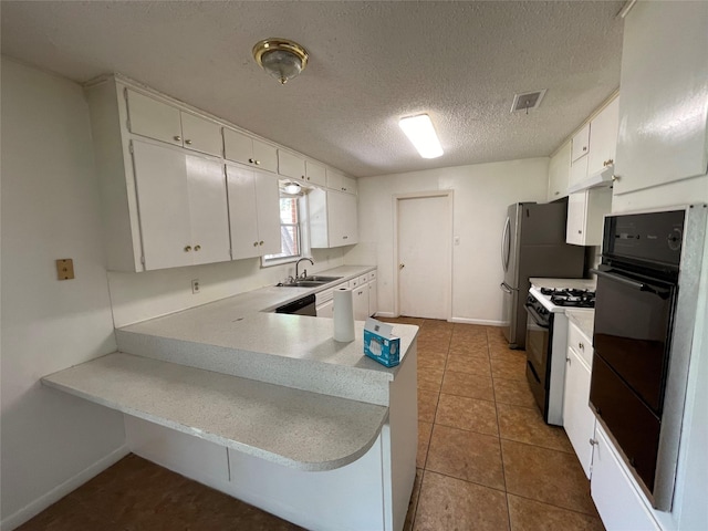 1703 Larkwood Ct, Austin, TX 78723 - kitchen featuring range with gas stovetop, black oven, white cabinets, a peninsula, and a textured ceiling