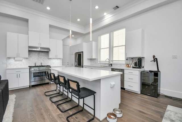 3302 Timbergrove Heights St, Houston, TX 77008 - kitchen featuring appliances with stainless steel finishes, ornamental molding, ventilation hood, a kitchen bar, and a center island