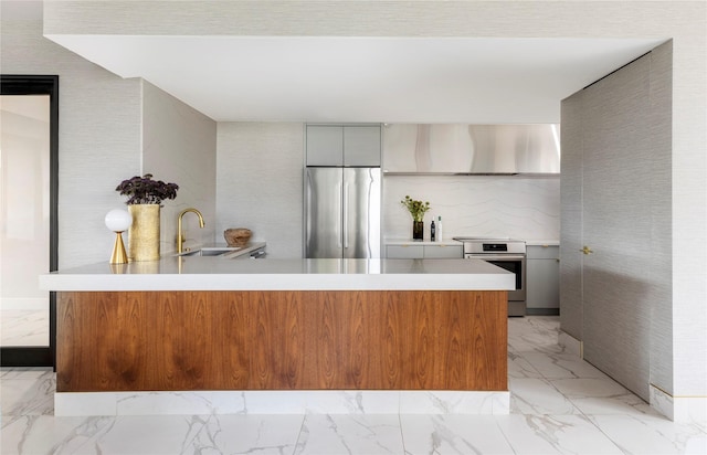 1111 Hermann Dr Unit 11F, Houston, TX 77004 - kitchen with appliances with stainless steel finishes, wall chimney range hood, light marble finish floors, light countertops, and a peninsula