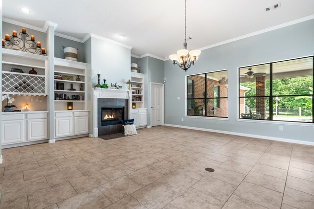 32210 Mink Creek Ct, Magnolia, TX 77355 - unfurnished living room featuring ornamental molding, built in features, a tiled fireplace, a chandelier, and light tile patterned floors