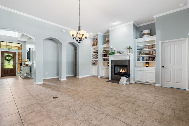 32210 Mink Creek Ct, Magnolia, TX 77355 - unfurnished living room with arched walkways, crown molding, built in features, a fireplace, and a chandelier