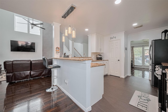 14212 Rocky Briar Ln, Rosharon, TX 77583 - kitchen with white cabinets, light stone countertops, hanging light fixtures, recessed lighting, and a peninsula