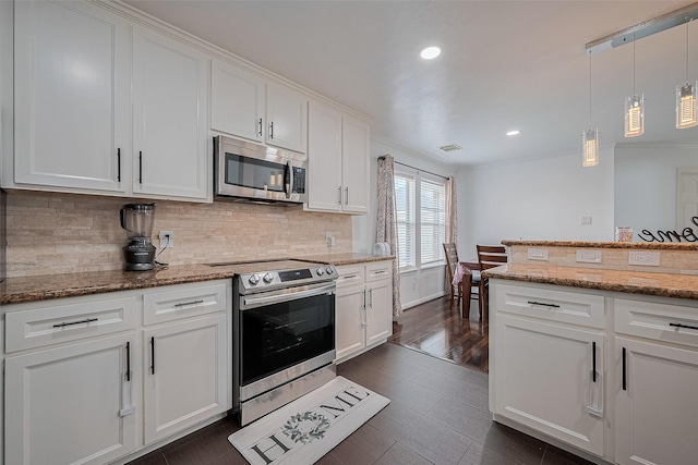 14212 Rocky Briar Ln, Rosharon, TX 77583 - kitchen featuring stainless steel appliances, tasteful backsplash, white cabinets, recessed lighting, and hanging light fixtures