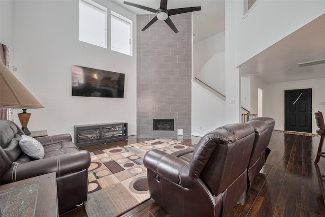 14212 Rocky Briar Ln, Rosharon, TX 77583 - living area featuring a high ceiling, a ceiling fan, wood-type flooring, stairway, and a tile fireplace