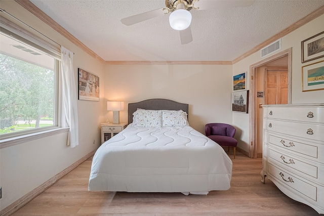 674 S Ripple Creek Dr Unit 674, Houston, TX 77057 - bedroom featuring a textured ceiling, ornamental molding, light wood-style floors, and ceiling fan