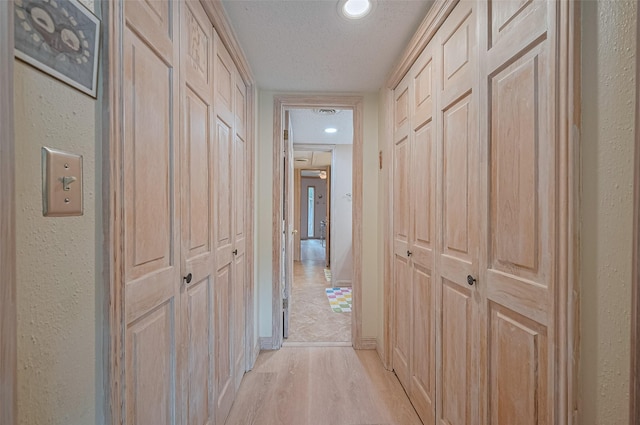 674 S Ripple Creek Dr Unit 674, Houston, TX 77057 - hallway with light wood-style floors, a textured ceiling, and a textured wall