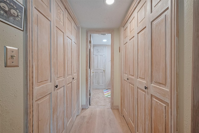 674 S Ripple Creek Dr Unit 674, Houston, TX 77057 - corridor with a textured wall, a textured ceiling, and light wood-style flooring
