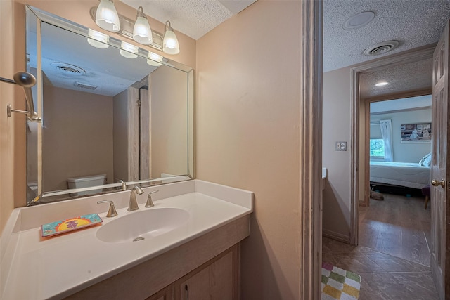 674 S Ripple Creek Dr Unit 674, Houston, TX 77057 - bathroom with a textured ceiling, vanity, connected bathroom, and tile patterned flooring
