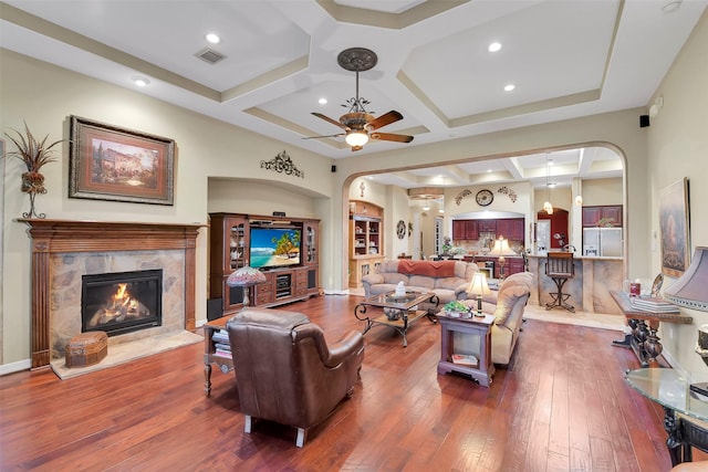 5702 Silverthorn Glen Dr, Spring, TX 77379 - living area with arched walkways, coffered ceiling, a premium fireplace, wood-type flooring, and a ceiling fan