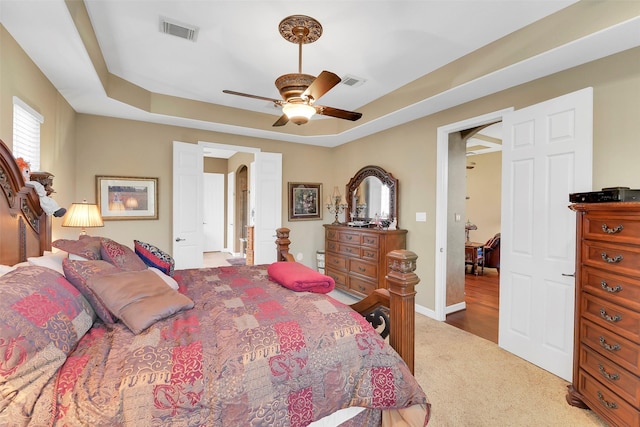 5702 Silverthorn Glen Dr, Spring, TX 77379 - carpeted bedroom with arched walkways, a ceiling fan, and a tray ceiling