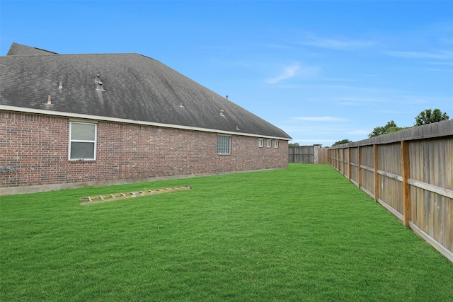 5702 Silverthorn Glen Dr, Spring, TX 77379 - rear view of house with a fenced backyard, brick siding, and roof with shingles