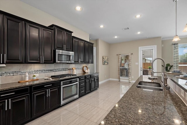 18135 Berry Garden Ln, Spring, TX 77379 - kitchen featuring appliances with stainless steel finishes, dark stone countertops, hanging light fixtures, recessed lighting, and decorative backsplash