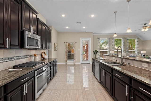 18135 Berry Garden Ln, Spring, TX 77379 - kitchen featuring stainless steel appliances, backsplash, dark stone countertops, a ceiling fan, and decorative light fixtures